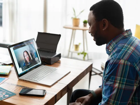 A man is taking an online consultation regarding his course through his laptop